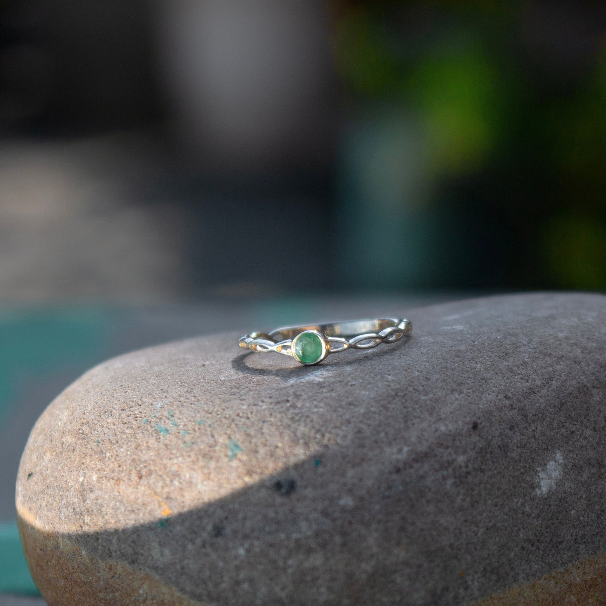 925 silver Ring with faceted round tiny Emerald set in bezel in an infinity band style in high Polish