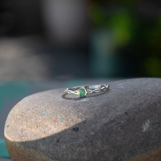 925 silver Ring with faceted round tiny Emerald set in bezel in an infinity band style in high Polish